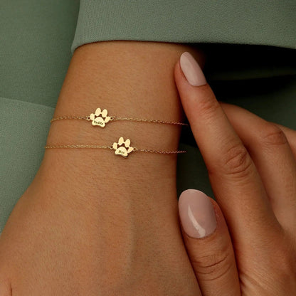 Close-up of engraved pet paw print and name on dainty gold bracelet — waterproof daily wear