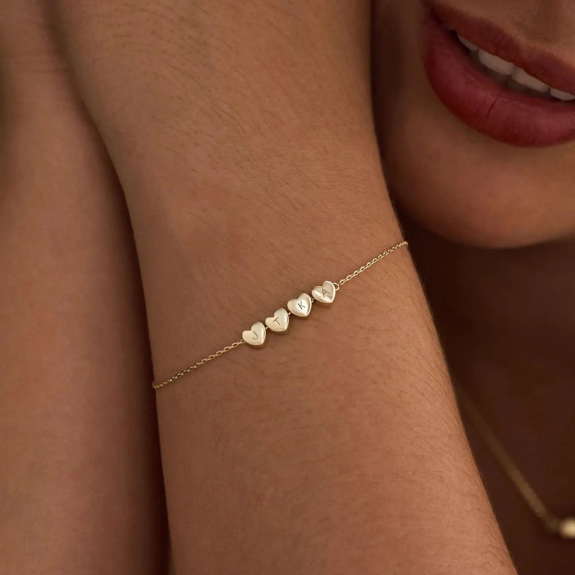 Heart initial bracelet styled on woman's wrist — romantic everyday personalized jewelry