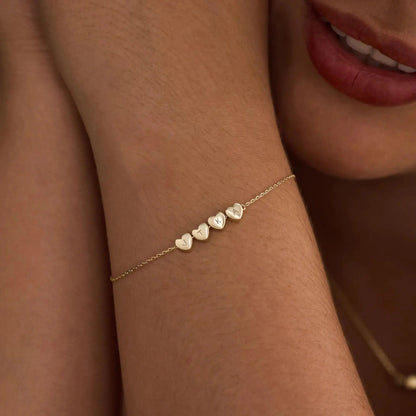 Heart initial bracelet styled on woman's wrist — romantic everyday personalized jewelry