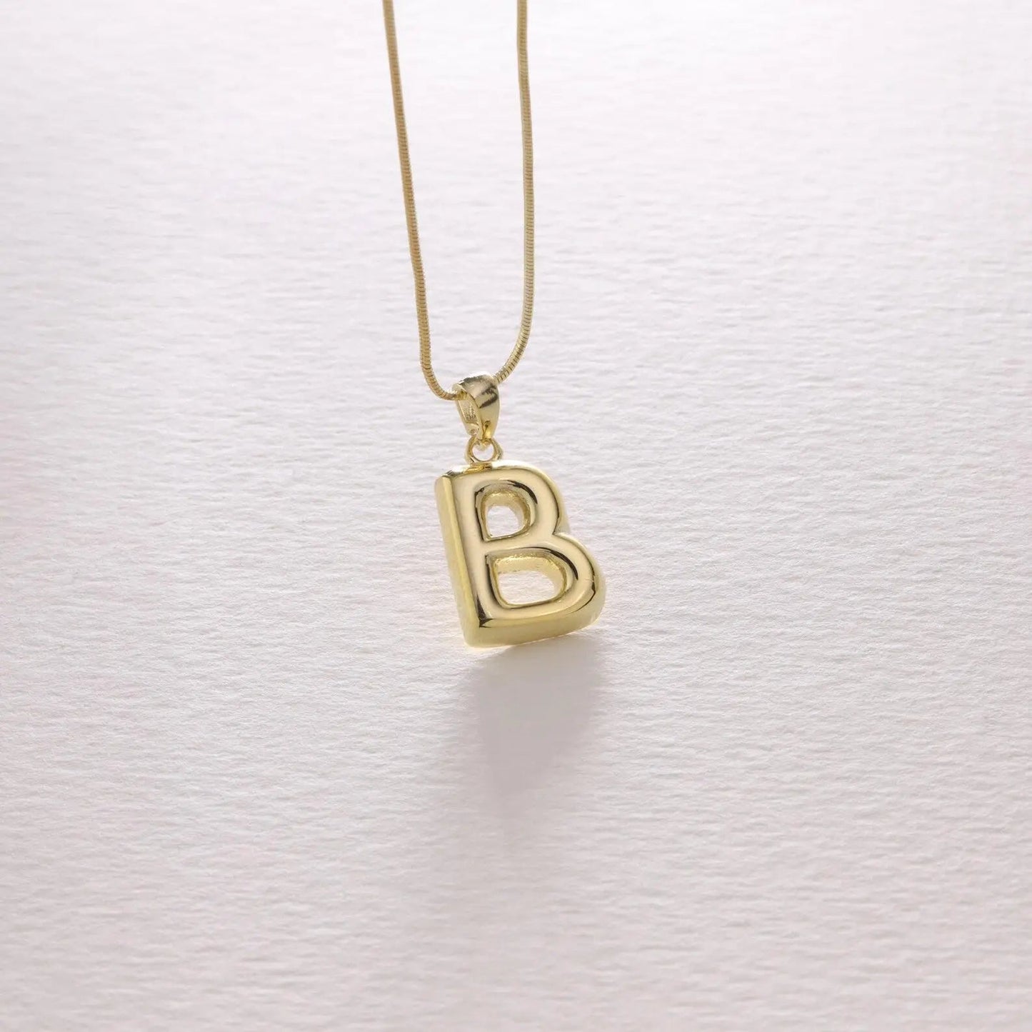 Bubble letter necklace in gold styled with casual outfit — bold personalized statement jewelry