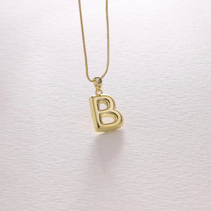 Bubble letter necklace in gold styled with casual outfit — bold personalized statement jewelry