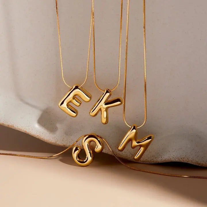Custom Y2K bubble letter pendant detail — engraved monogram in tarnish-resistant stainless steel