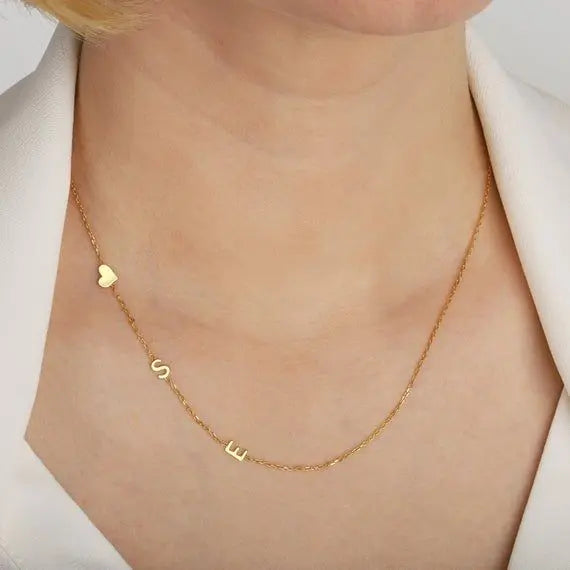 Close-up of engraved sideways letter pendant on dainty chain — handmade personalized necklace