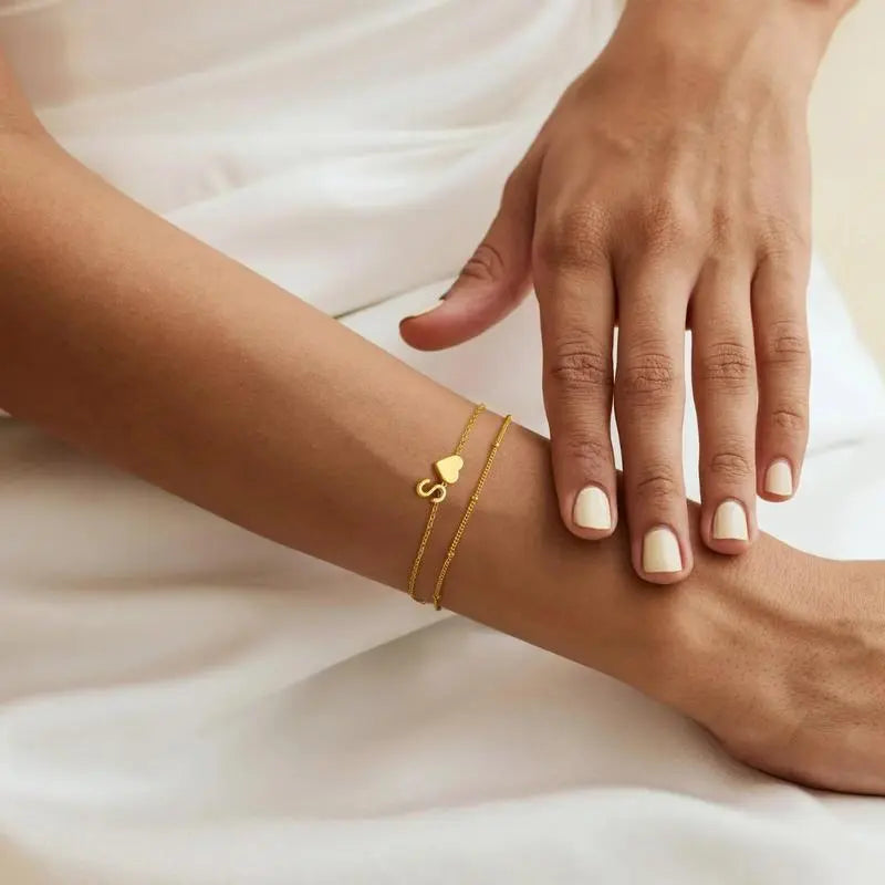 Heart initial bracelet styled on woman's wrist — minimalist everyday romantic accessory