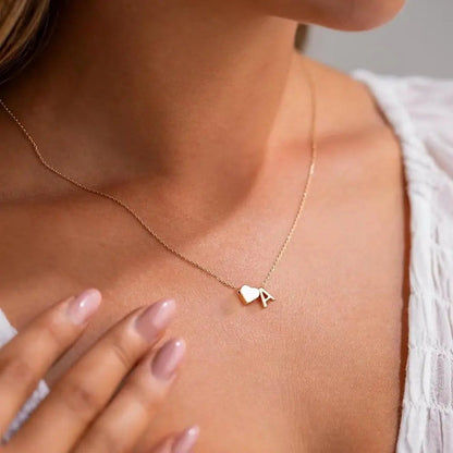 Heart initial necklace close-up — engraved monogram in tarnish-resistant stainless steel