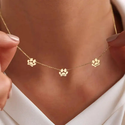 Multi-pet paw necklace beside pet photos — emotional keepsake for grieving multi-pet parents